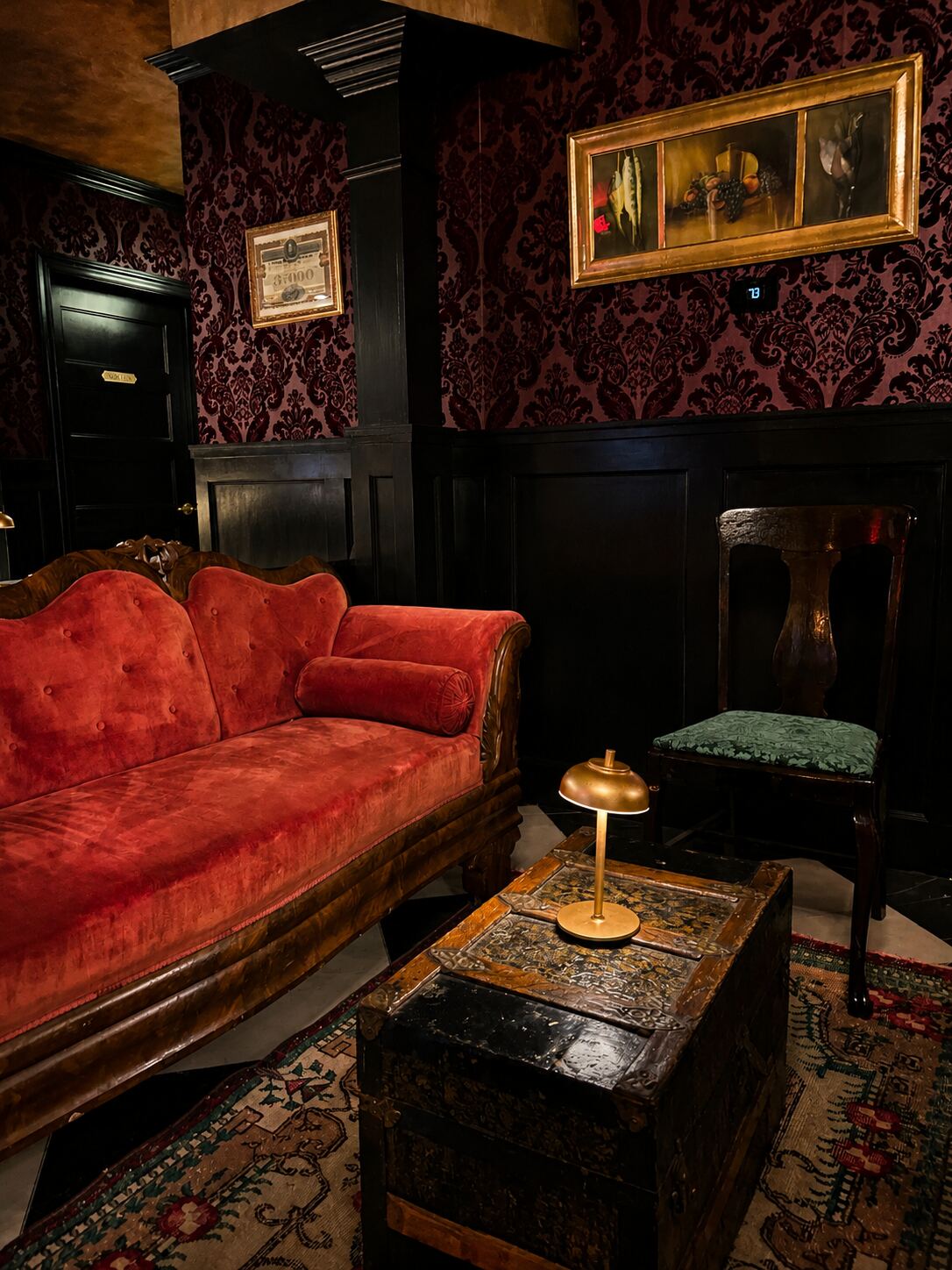 Red velvet sofa against damask wallpaper